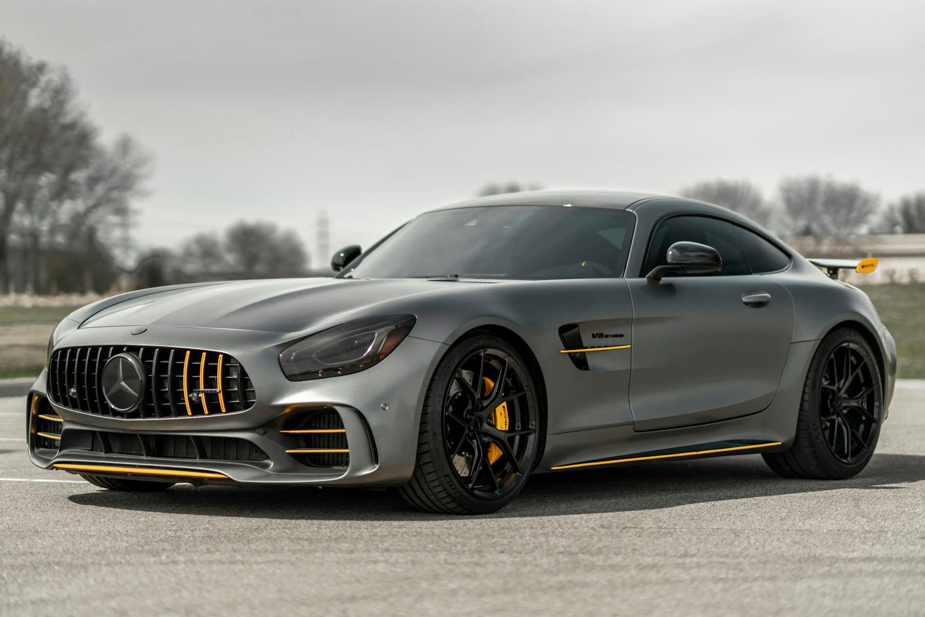 Satin grey Mercedes-AMG GT R with gold accents parked on a quiet road
