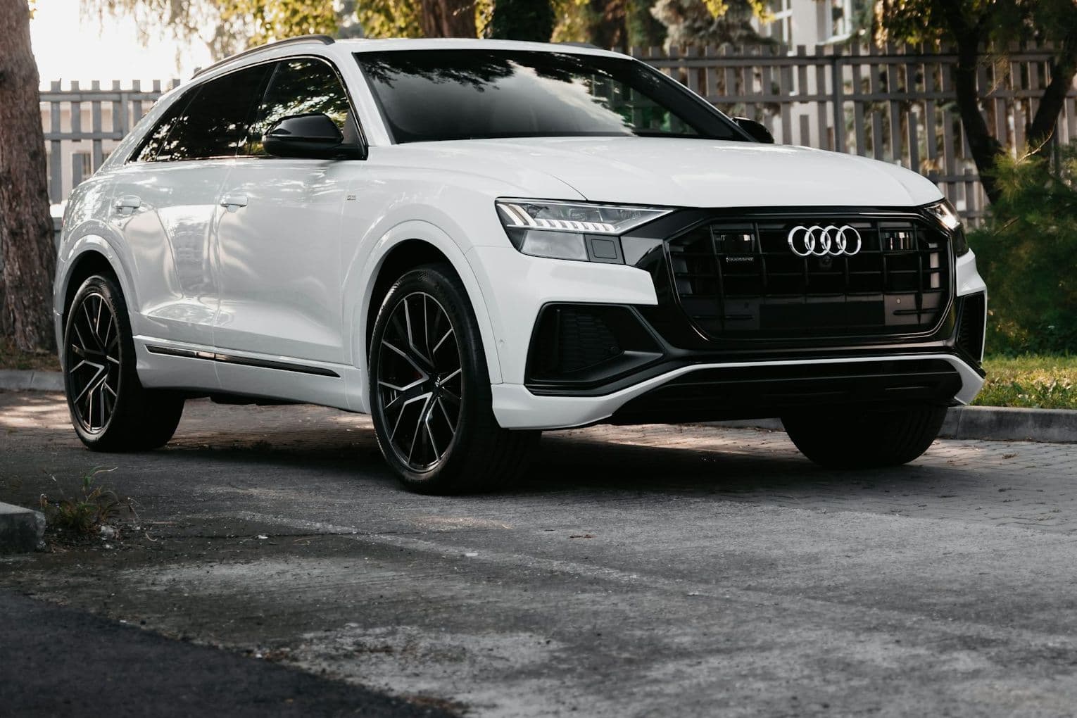 Front three-quarter view of the white Audi Q8 with black grille