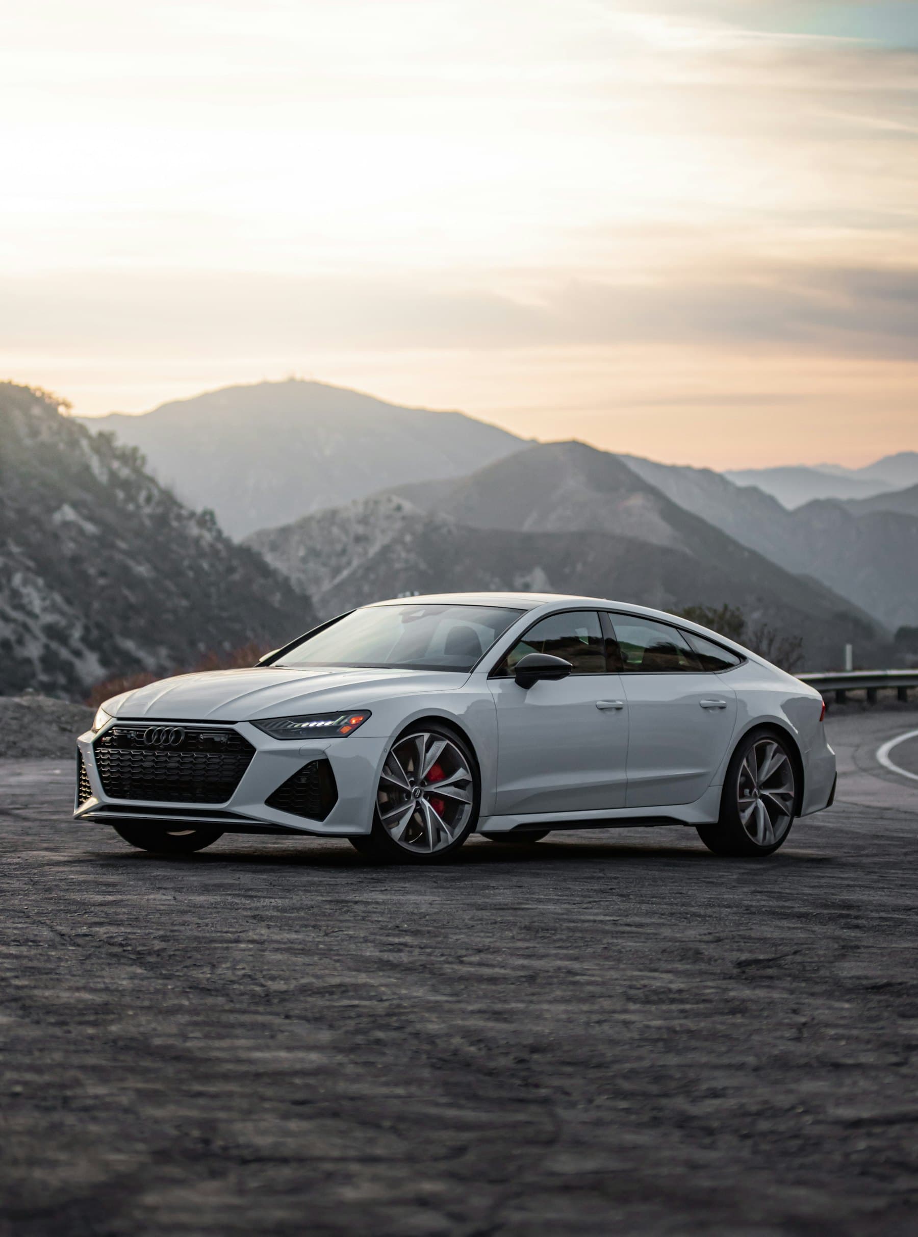 Silver Audi RS 7 Sportback parked in front of a mountain range