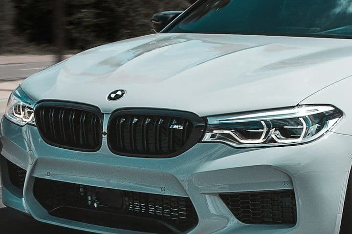 Front view of the white BMW M5 showing its kidney grille and air intakes