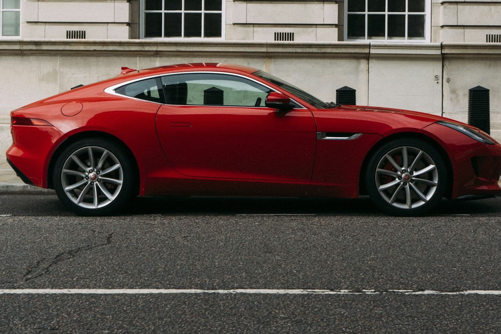 Full side profile of the red Jaguar F-Type coupe