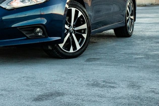 Wheel and lower bodywork of the blue Nissan Altima