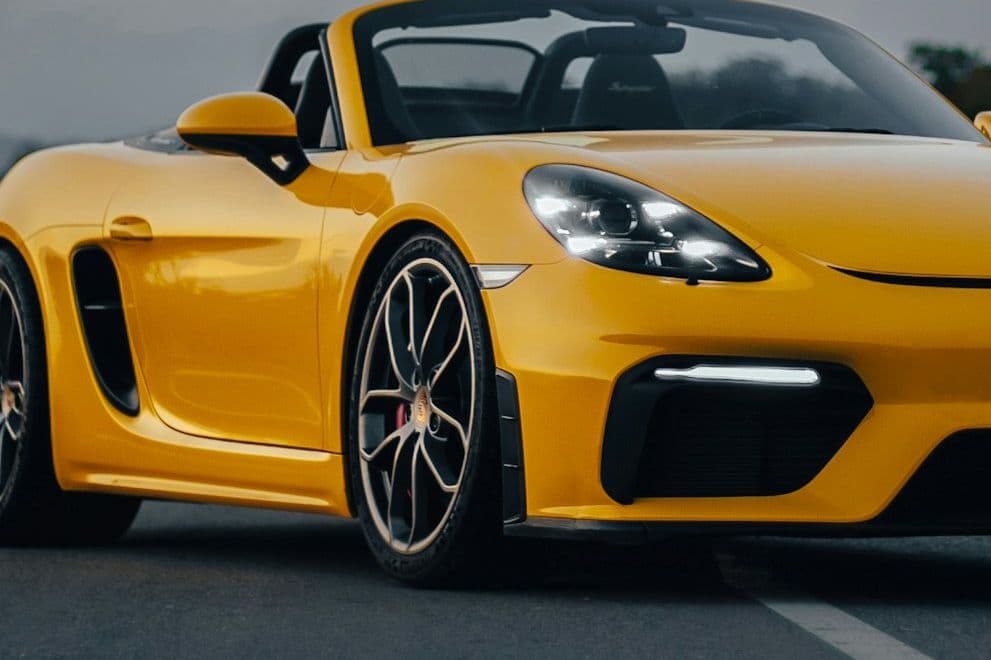 Front wheel and side intake detail of the yellow Porsche 718 Spyder