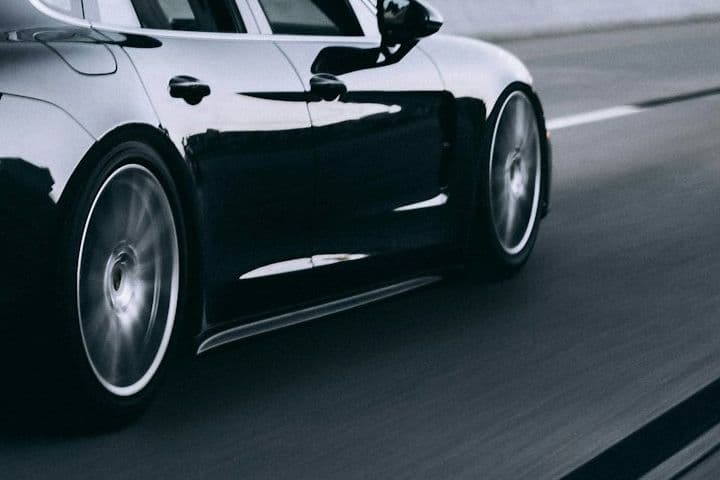 Side view of the black Porsche Panamera rear wheel in motion