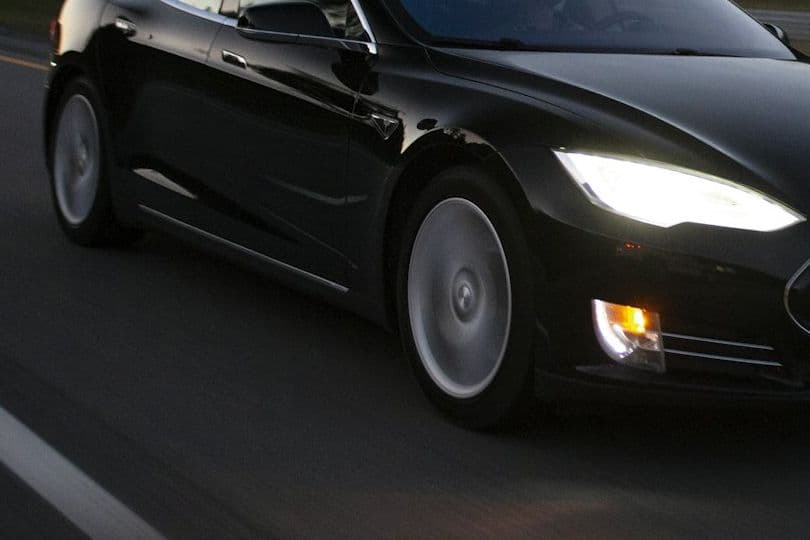 Close view of the Tesla Model S front wheel and headlight in motion