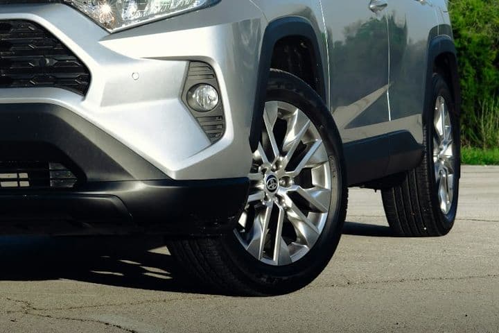 Front wheel and lower bumper detail of the silver Toyota RAV4